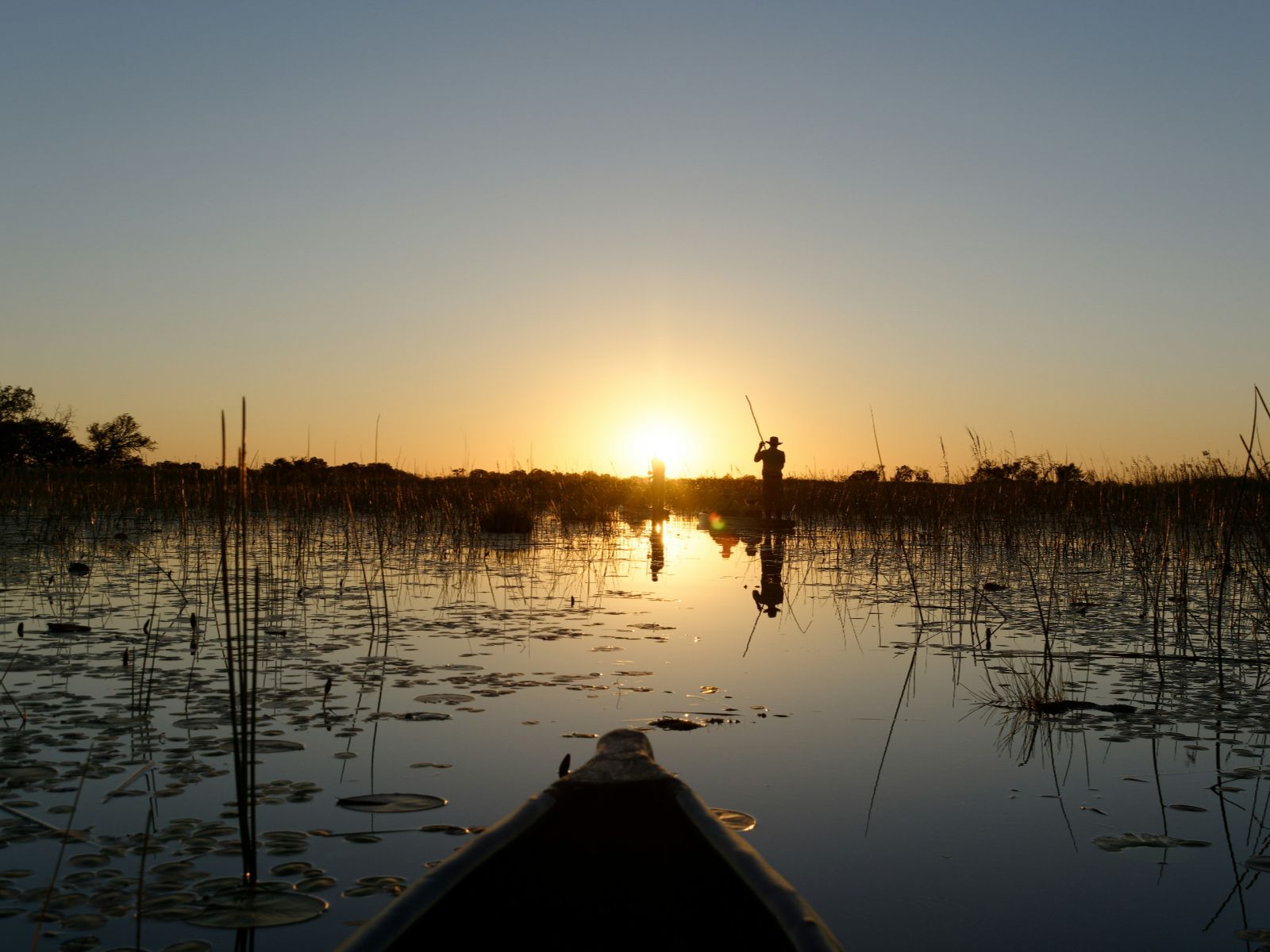 Rondreis Botswana, Maun, excursie Full Day Mokoro Tour, Bootje op de rivier met zonsondergang