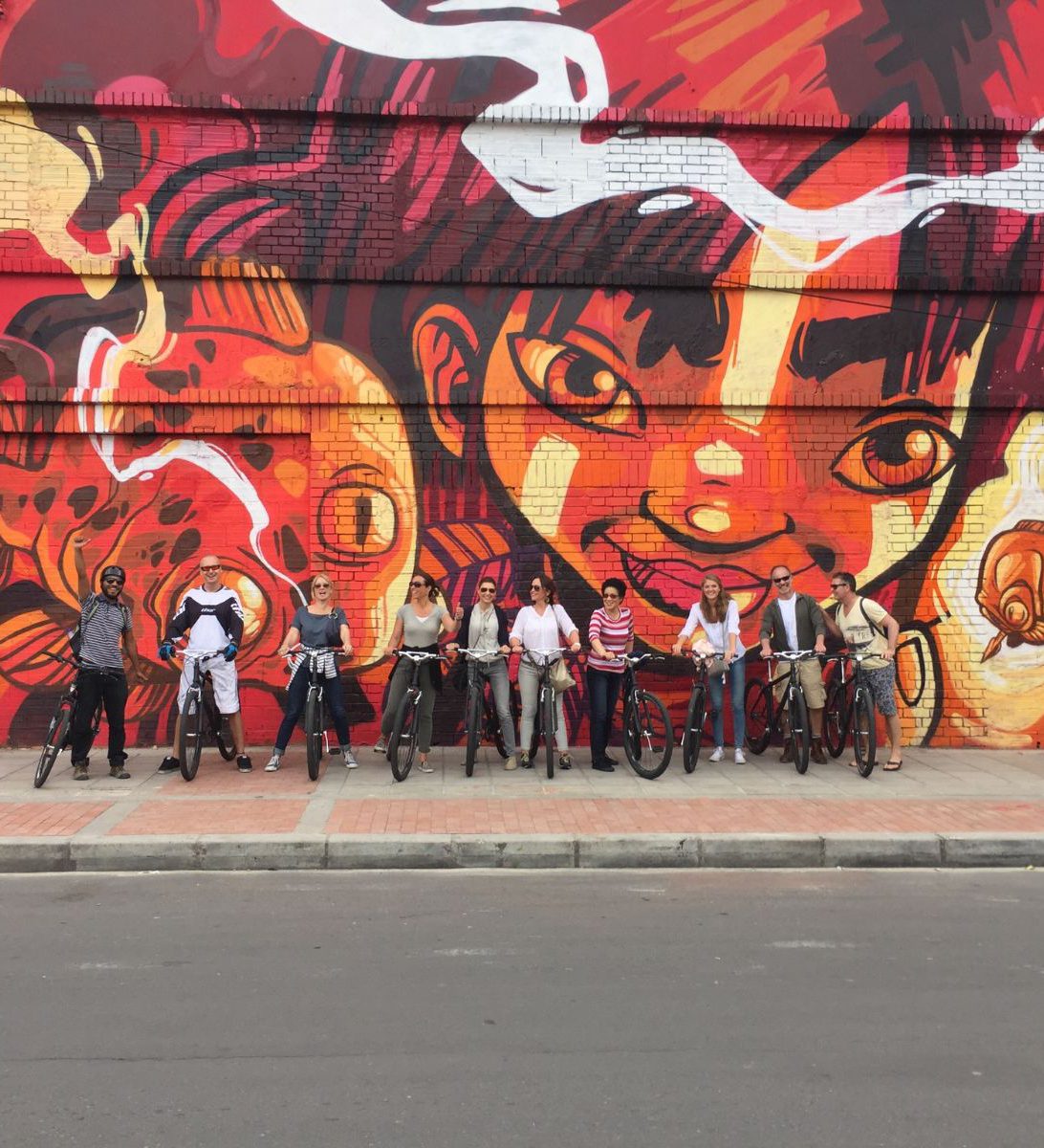Rondreis Colombia, Bogotá, excursie op de fiets door Bogotá, groep fietsers voor een streetart