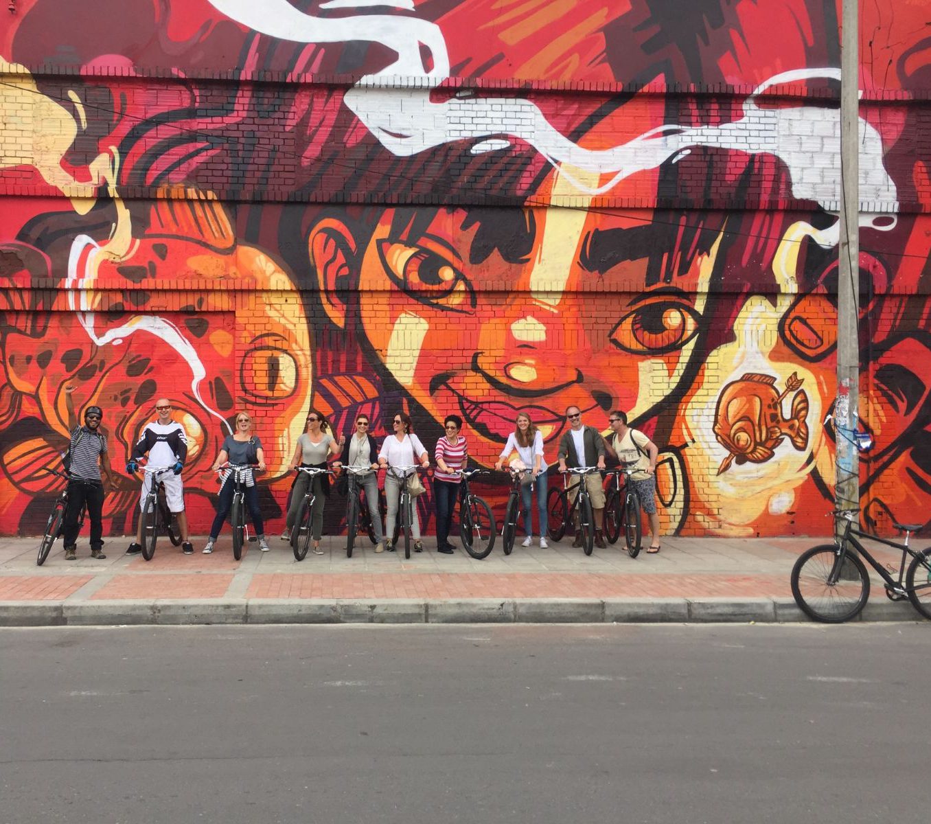 Rondreis Colombia, Bogotá, excursie op de fiets door Bogotá, groep fietsers voor een streetart