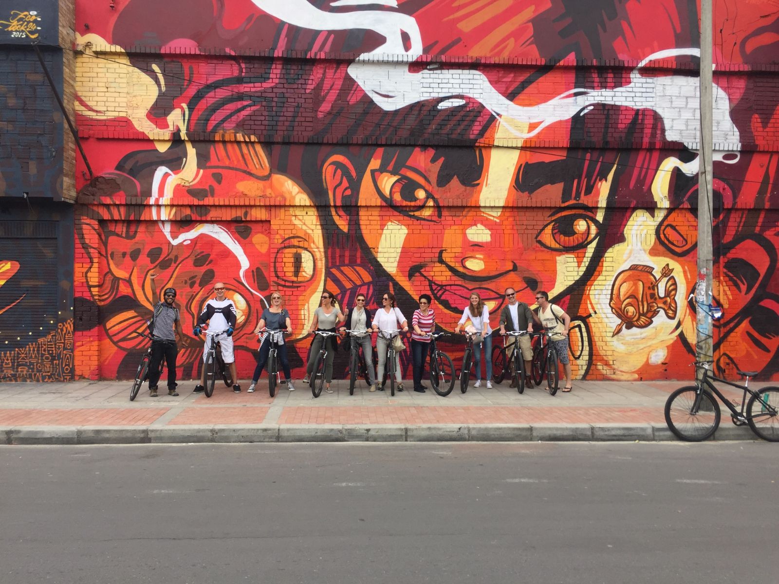 Rondreis Colombia, Bogotá, excursie op de fiets door Bogotá, groep fietsers voor een streetart