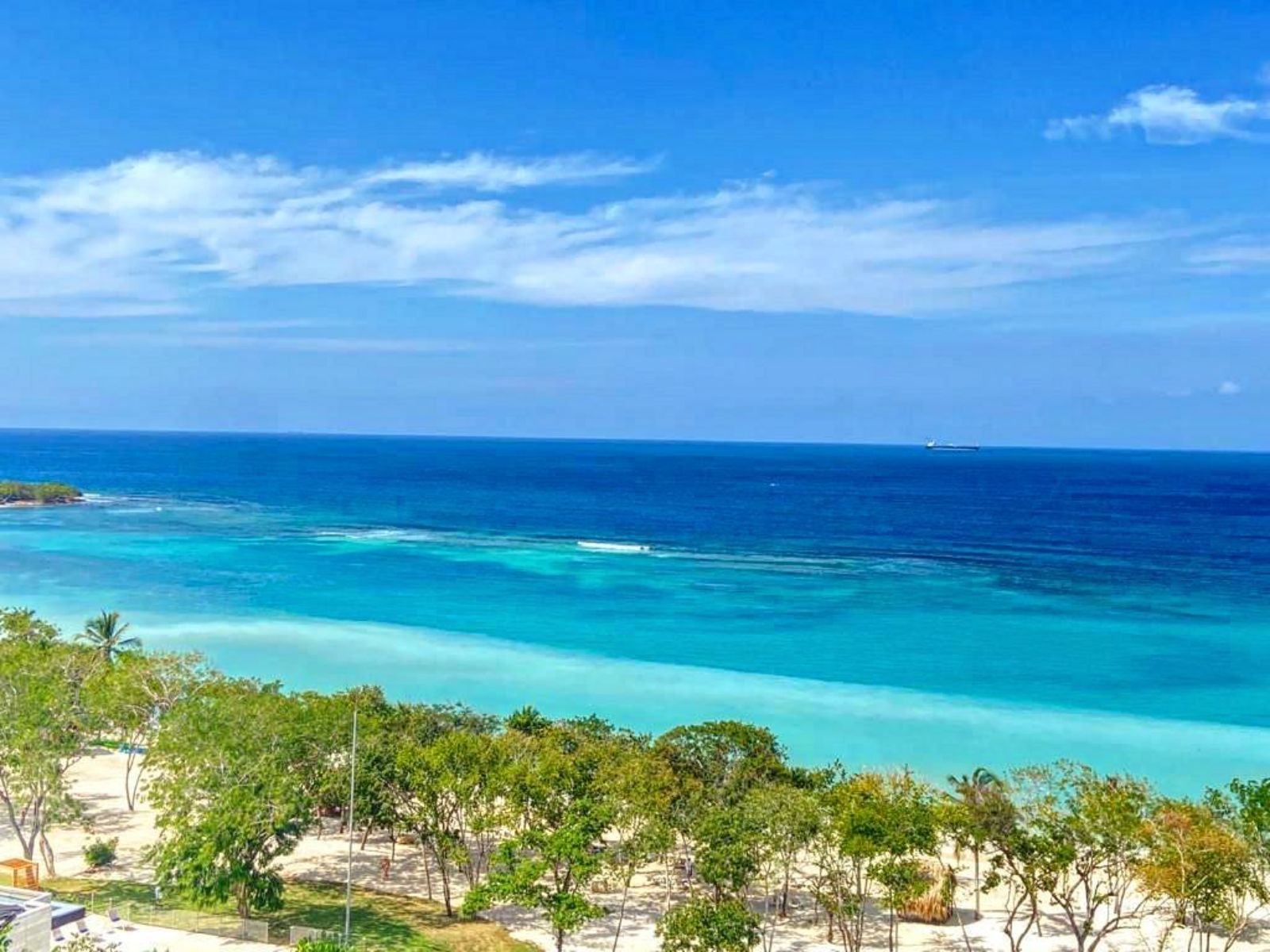 Rondreis Colombia, Cartagena, excursie caribisch stranddagje op Isla Barú, tropisch strand met blauwe lucht