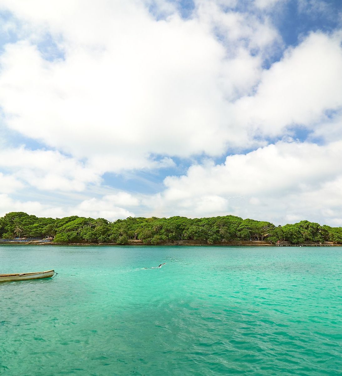 Rondreis Colombia, Cartagena, excursie dagtour naar tropisch Isla Majagua, zee en kust met blauwe lucht en wolken