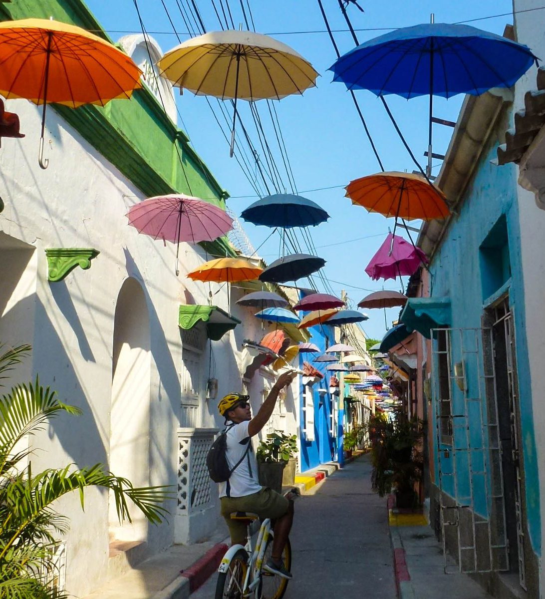 Rondreis-Colombia-Cartagena-excursie-street-art-en-graffiti-tour-Getsemani-fietser-in-steegje-aspect-ratio-382-420