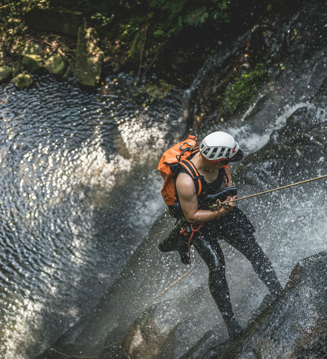 Rondreis Costa Rica, Rincon de la Vieja, excursie canyoning avontuur in Rincon de la Vieja, Man die abseilt naar beneden