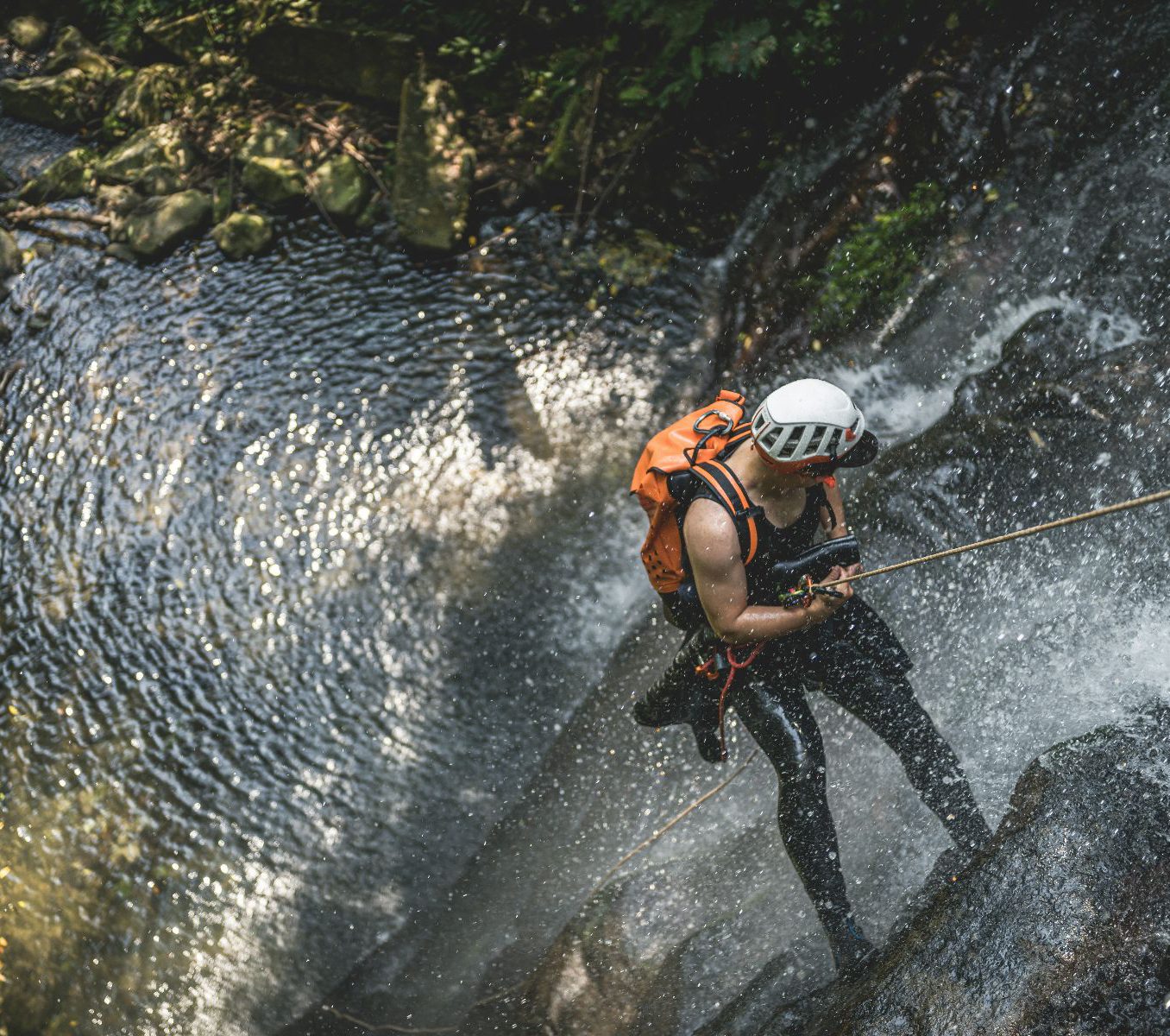 Rondreis Costa Rica, Rincon de la Vieja, excursie canyoning avontuur in Rincon de la Vieja, Man die abseilt naar beneden