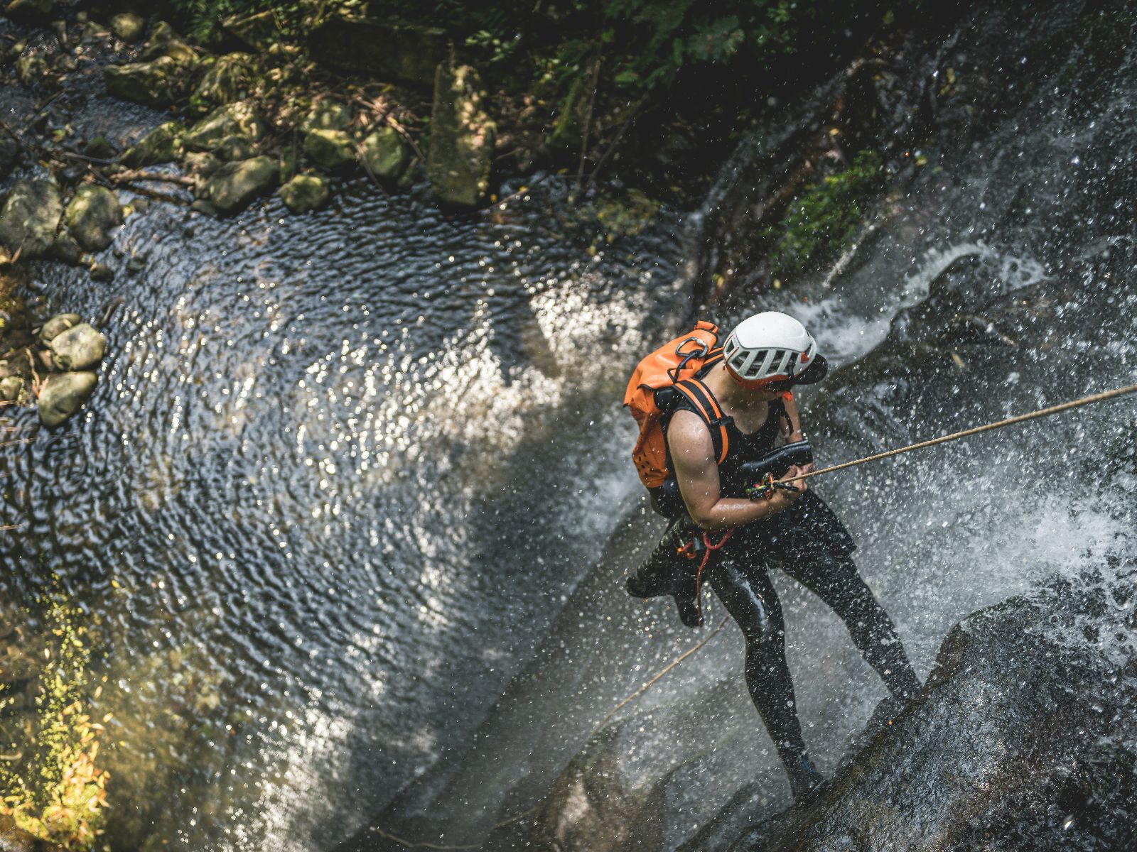 Rondreis Costa Rica, Rincon de la Vieja, excursie canyoning avontuur in Rincon de la Vieja, Man die abseilt naar beneden