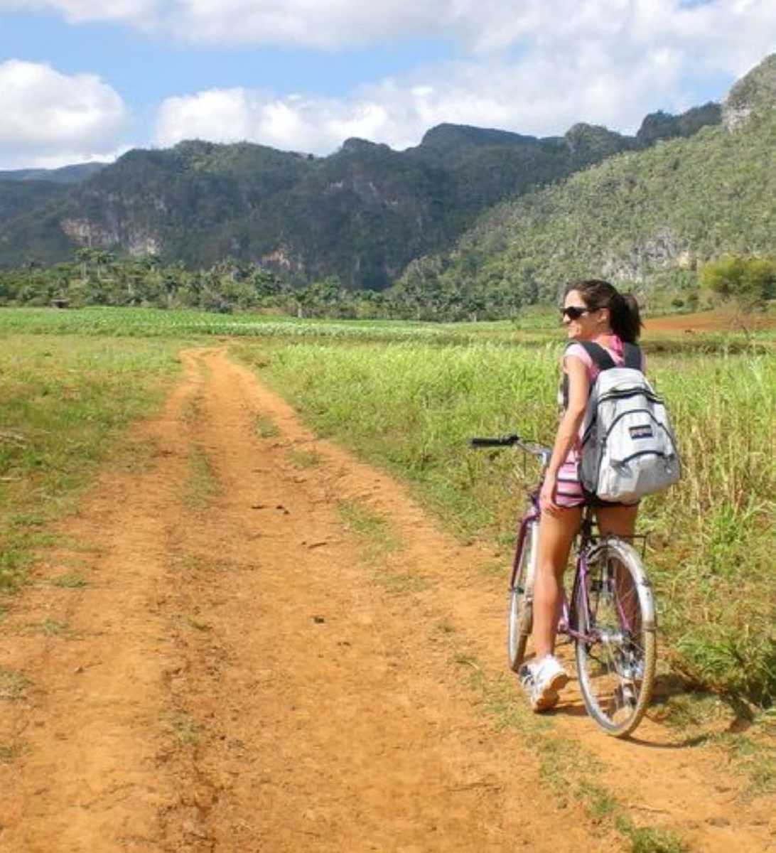 Rondreis Cuba, Viñales, Fietstour door de Viñales Vallei, vrouw op een fiets