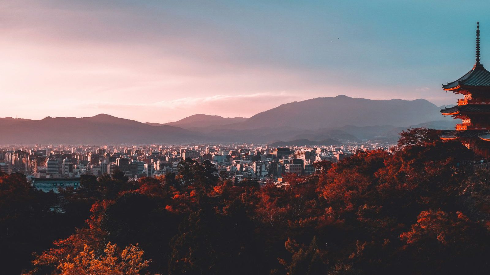 Rondreis Japan, Kiyozumi Dera, Kyoto, uitzicht over tempel, stad en bergen bij ochtendzon
