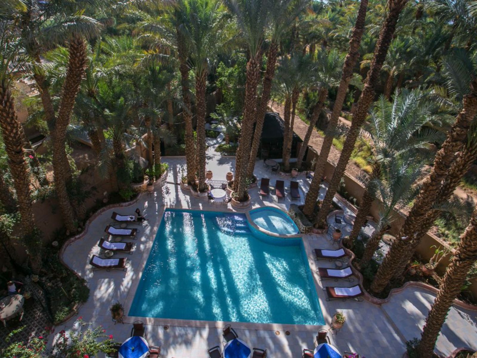 Rondreis Marokko, Zagora, Kasbah Sirocco, hotel zwembad met palmbomen en ligstoelen bovenaanzicht