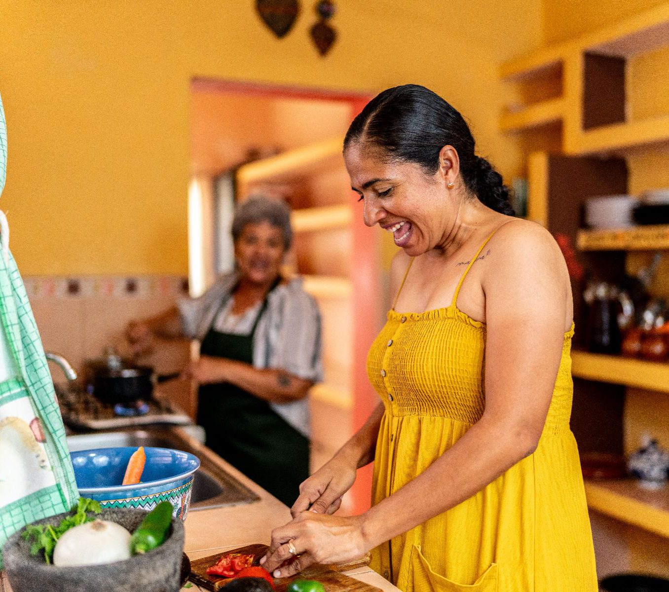 Rondreis Mexico, Merida-Oaxaca, Koken bij de locals in Merida, in de keuken bij locals, vrouw die groenten snijd