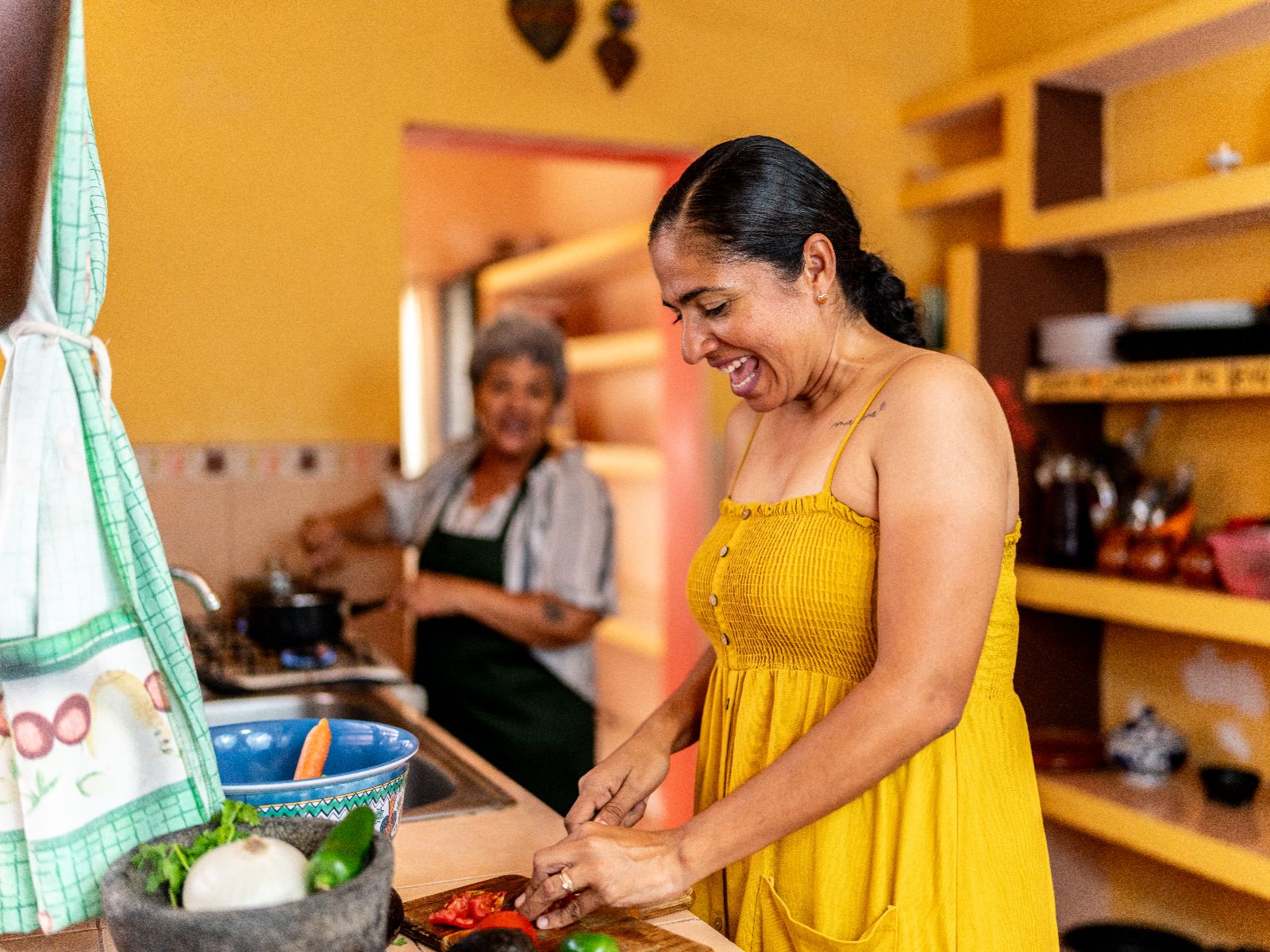 Rondreis Mexico, Merida-Oaxaca, Koken bij de locals in Merida, in de keuken bij locals, vrouw die groenten snijd