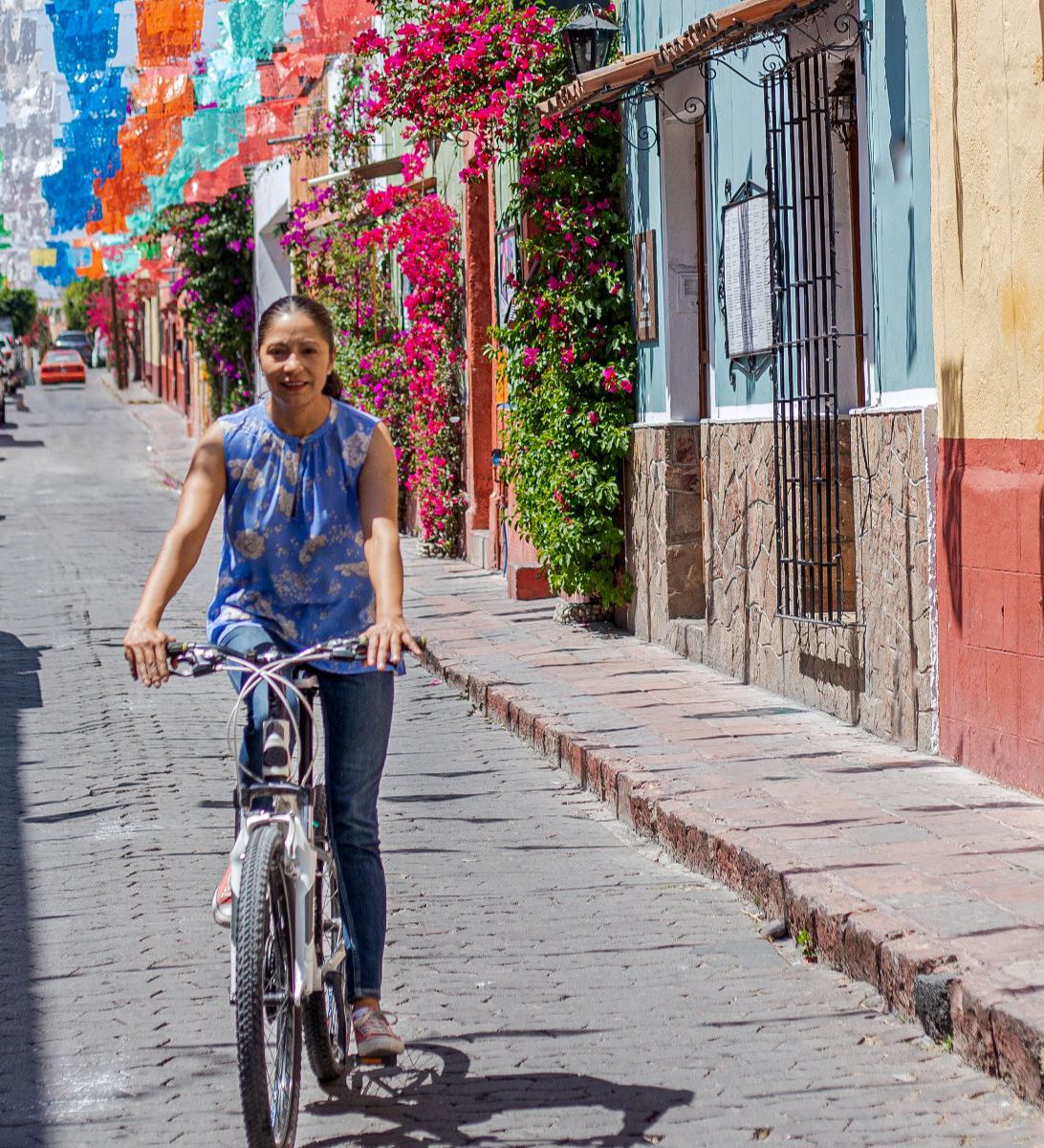 Rondreis Mexico, Mexico-Stad, Fietstour Urban Gallery Mexico-Stad, vrouw op een fiets door kleurrijke straat