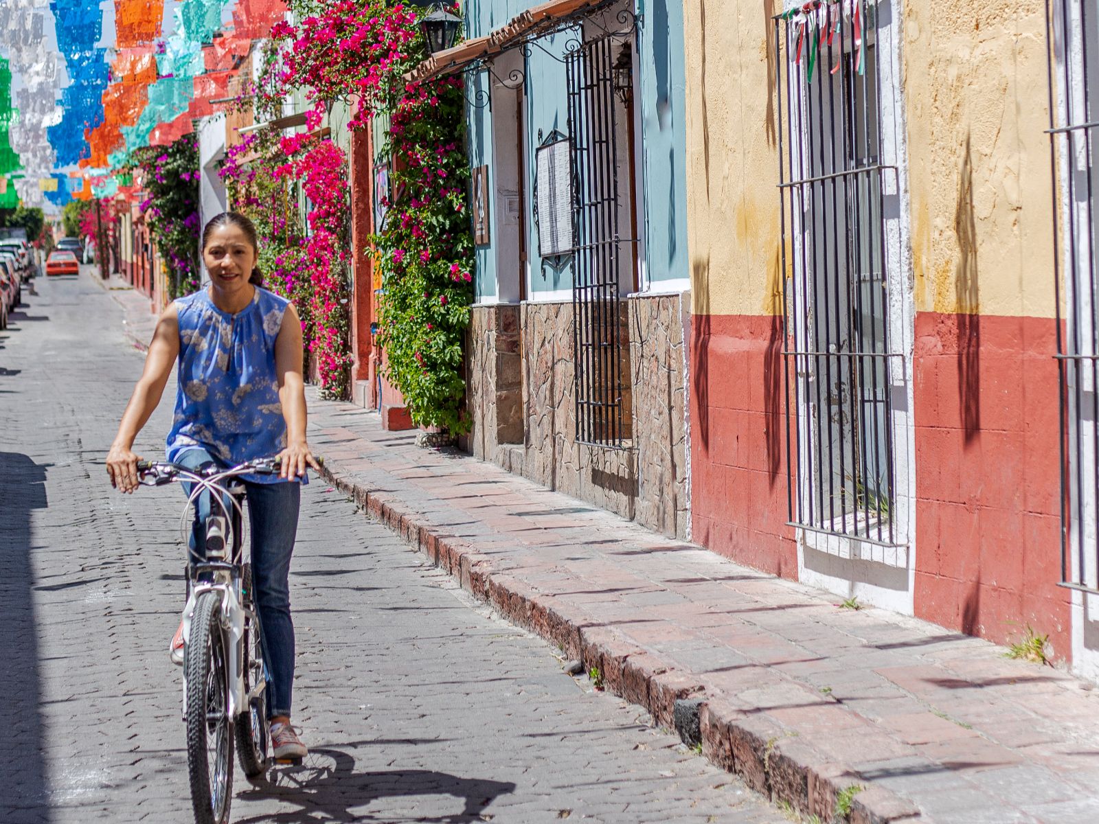 Rondreis Mexico, Mexico-Stad, Fietstour Urban Gallery Mexico-Stad, vrouw op een fiets door kleurrijke straat