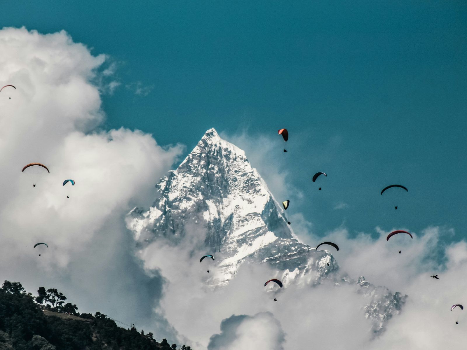 rondreis nepal, excursie paragliden, pokhara, paragliders met bergen op de achtergrond
