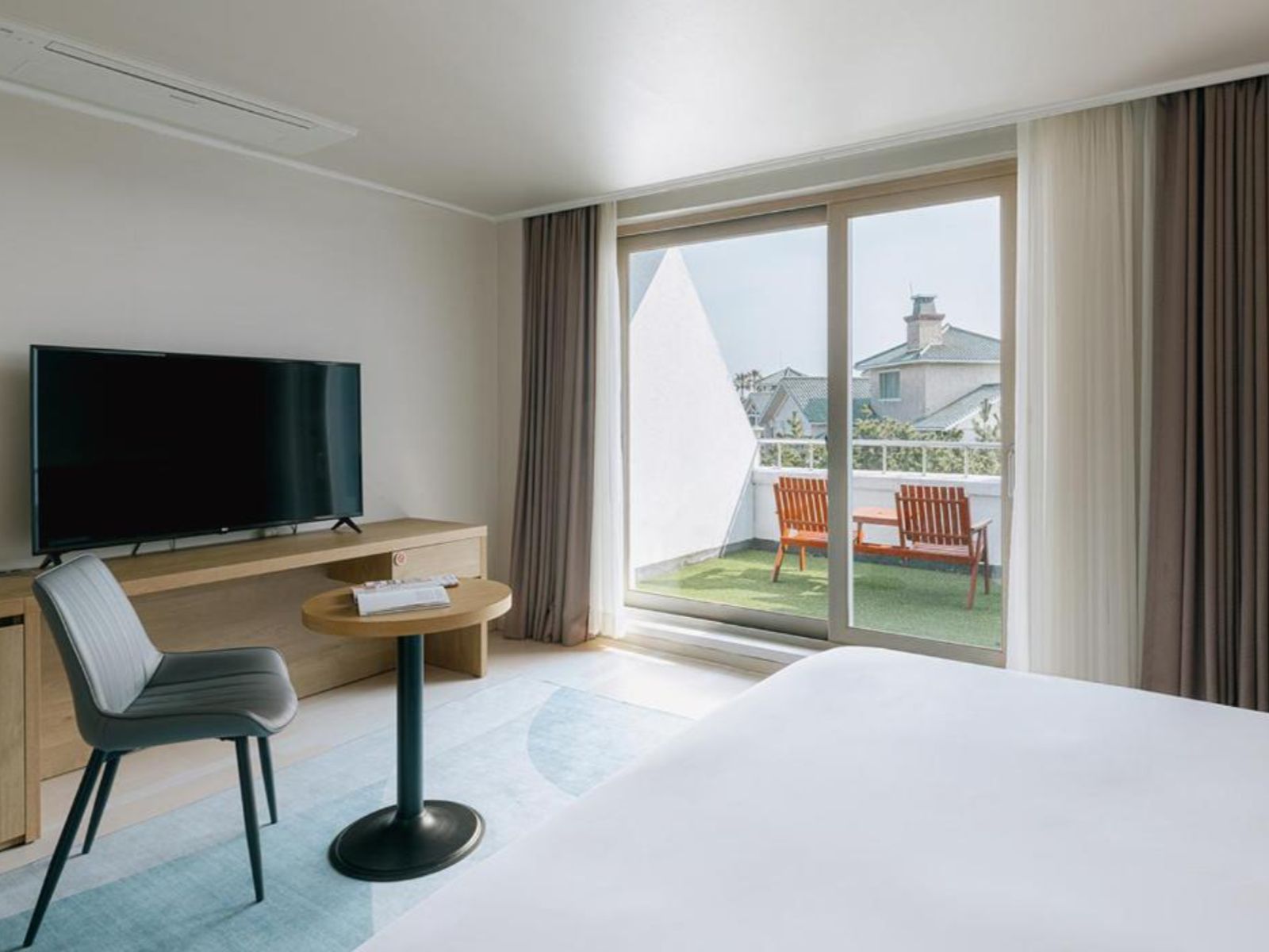Rondreis Zuid-Korea, Jeju-eiland, Bloom hotel, Slaapkamer met televisie en balkon