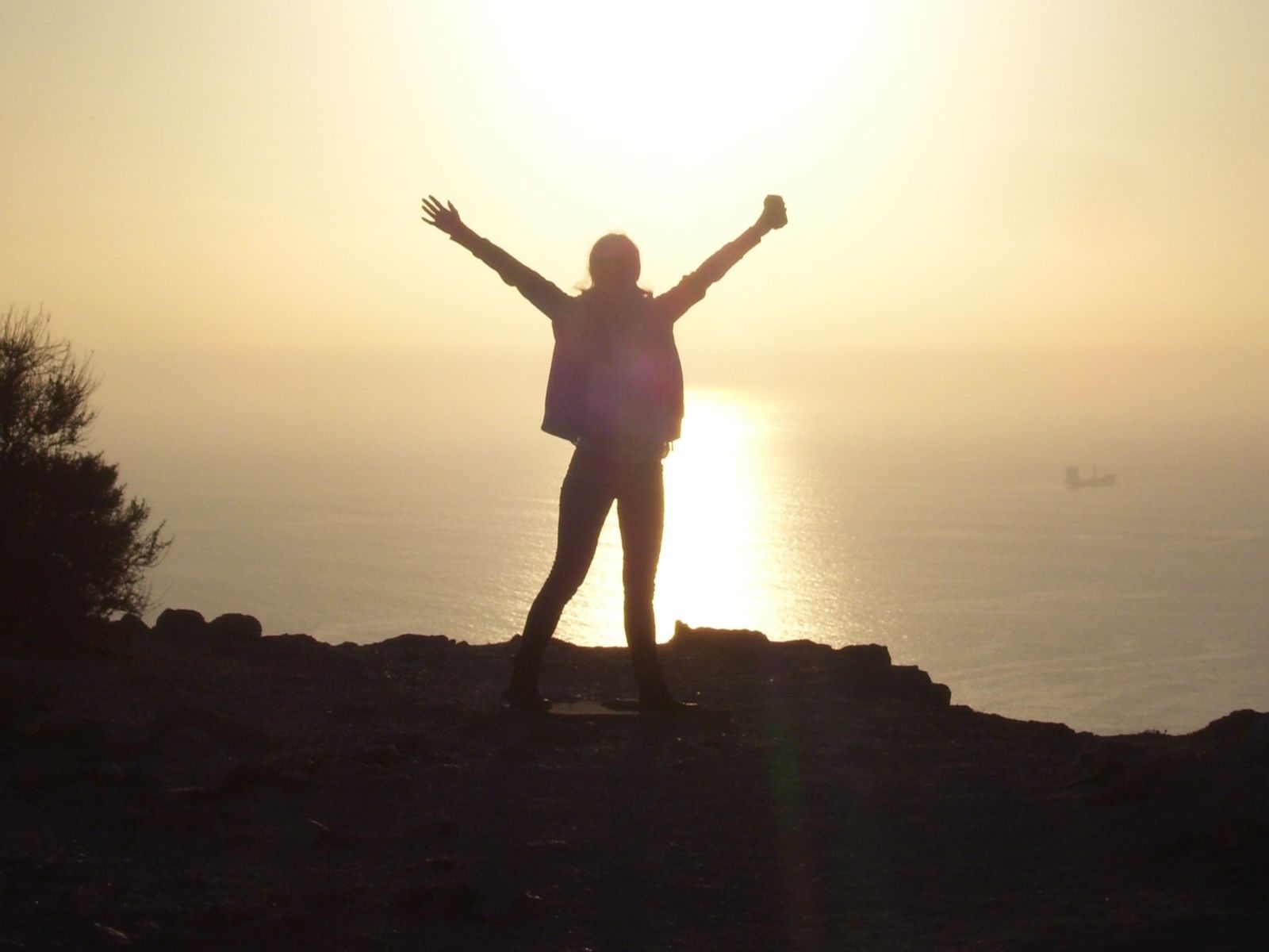 Rondreis Marokko, Agadir, iemand op een rots met zonsondergang
