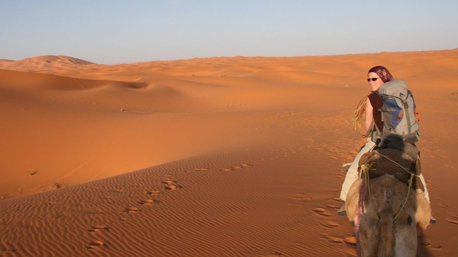 Rondreis Marokko, Erg Chebbi, vrouw op kameel door de woestijn