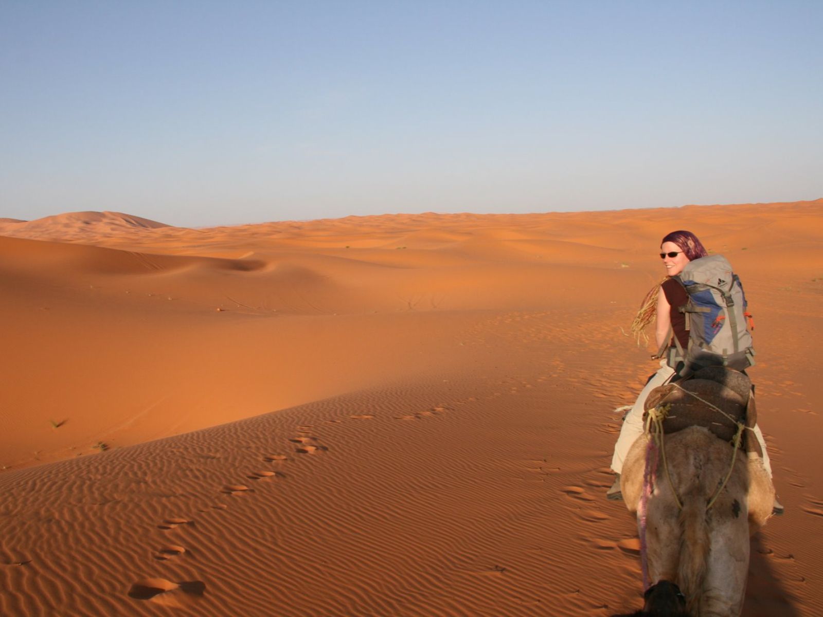 Rondreis Marokko, Erg Chebbi, vrouw op kameel door de woestijn