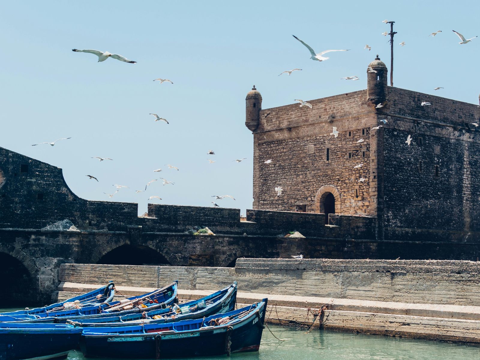 Rondreis Marokko, Essaouira, Excursie Kitesurfen, Bootjes aangelegd bij gebouw