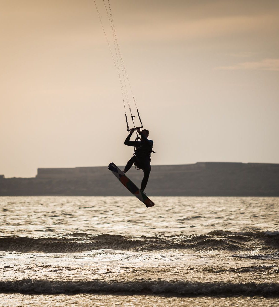 Rondreis Marokko, Essaouira, excursie Kitesurfen, kitesurfer op surfboard