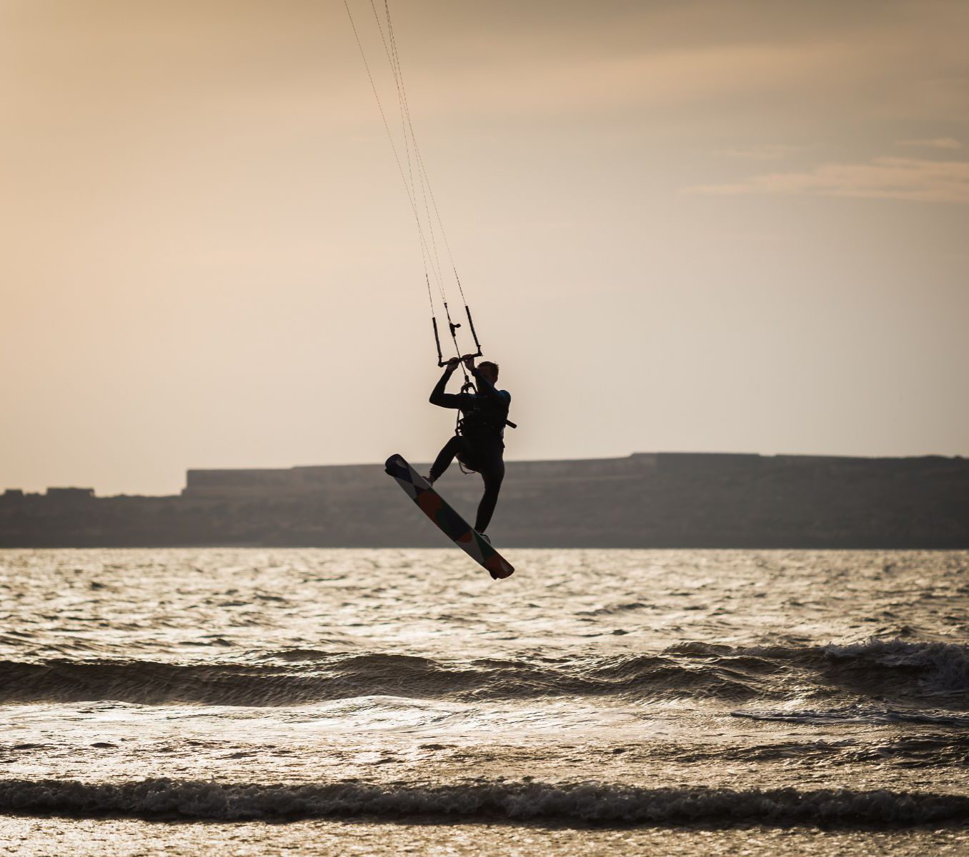 Rondreis Marokko, Essaouira, excursie Kitesurfen, kitesurfer op surfboard