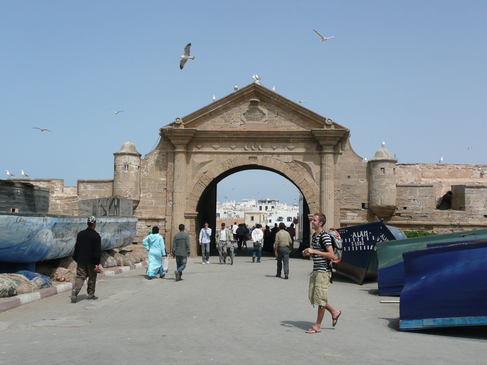 Rondreis Marokko, Essaouira, poort en meerdere lopende mensen