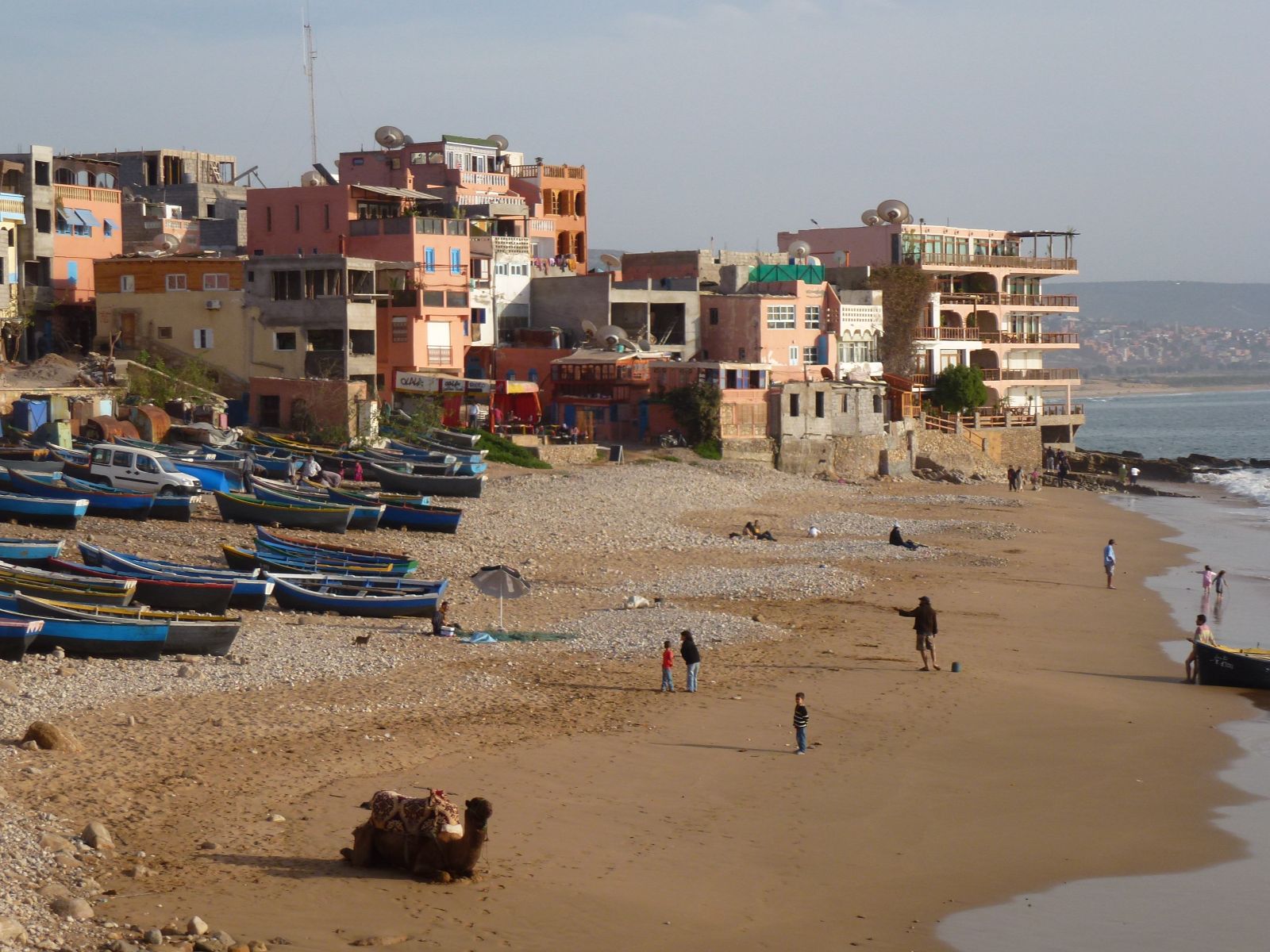Rondreis Marokko, Taghazout, strand met stad op de achtergrond
