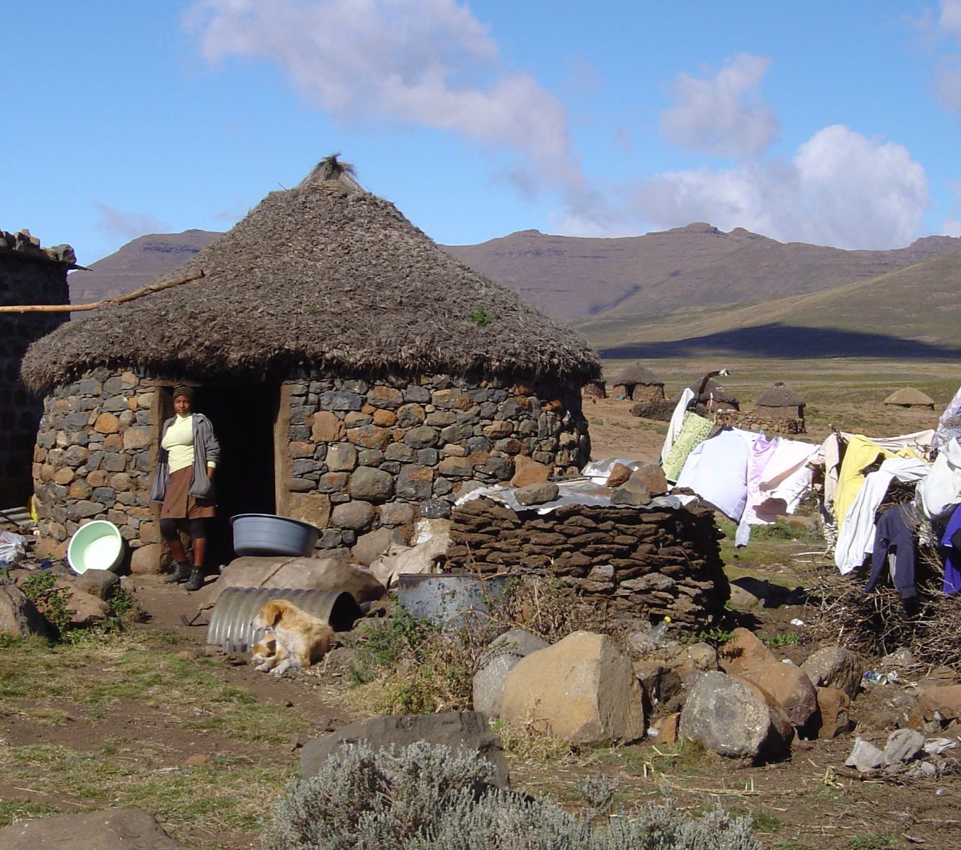 Rondreis Zuid-Afrika, Underberg, Excursie Sani Pass Day Tour, traditionele hut met vrouw