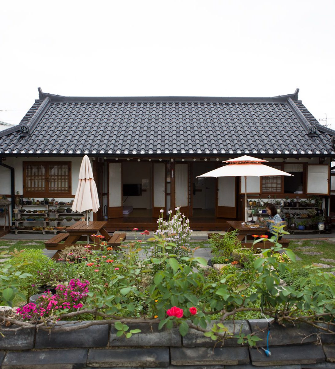 Rondreis Zuid-Korea, Gyeongju, Raon Hanok Stay, Tuin met tafels en buitenaanzicht van de kamers