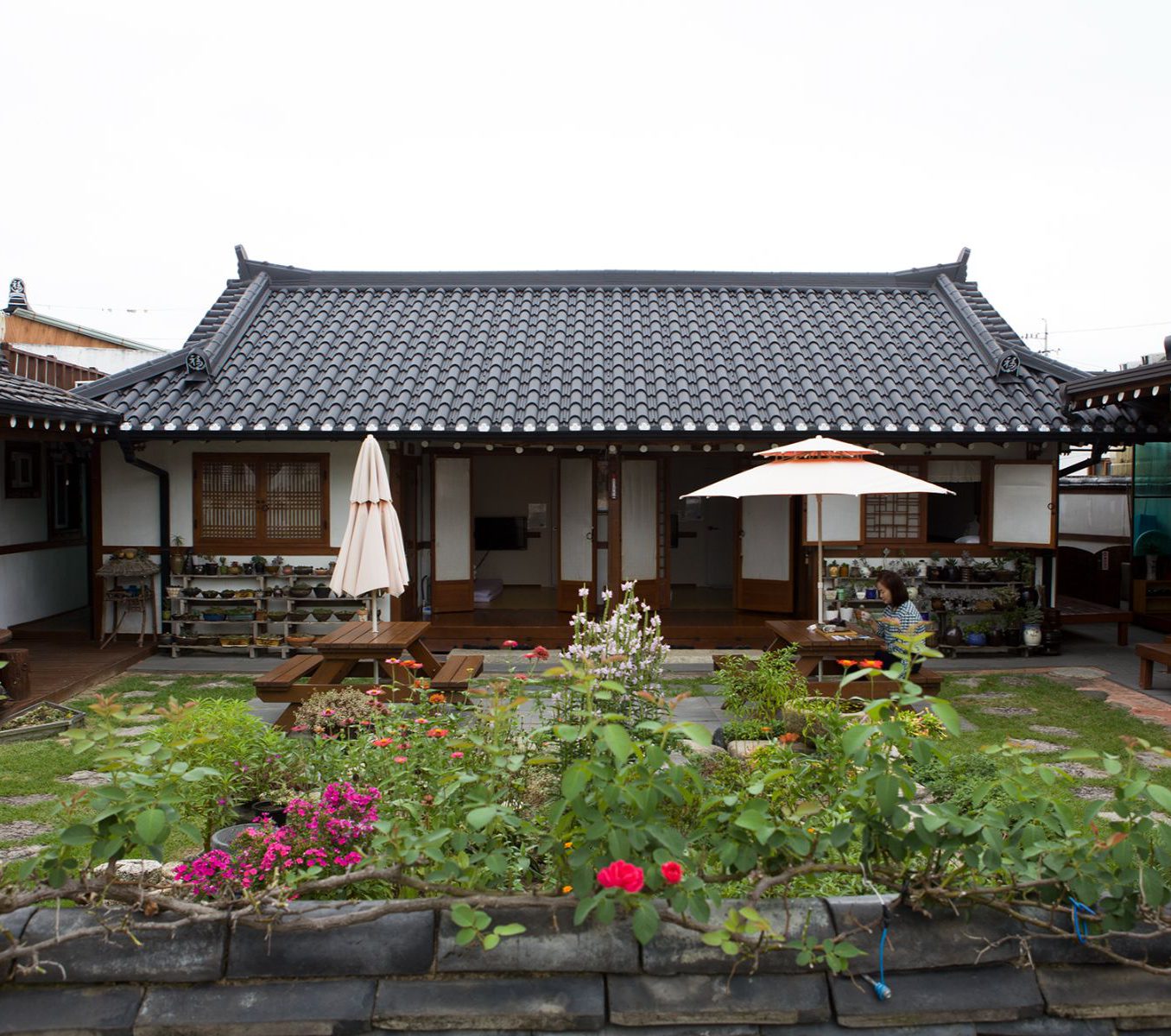 Rondreis Zuid-Korea, Gyeongju, Raon Hanok Stay, Tuin met tafels en buitenaanzicht van de kamers
