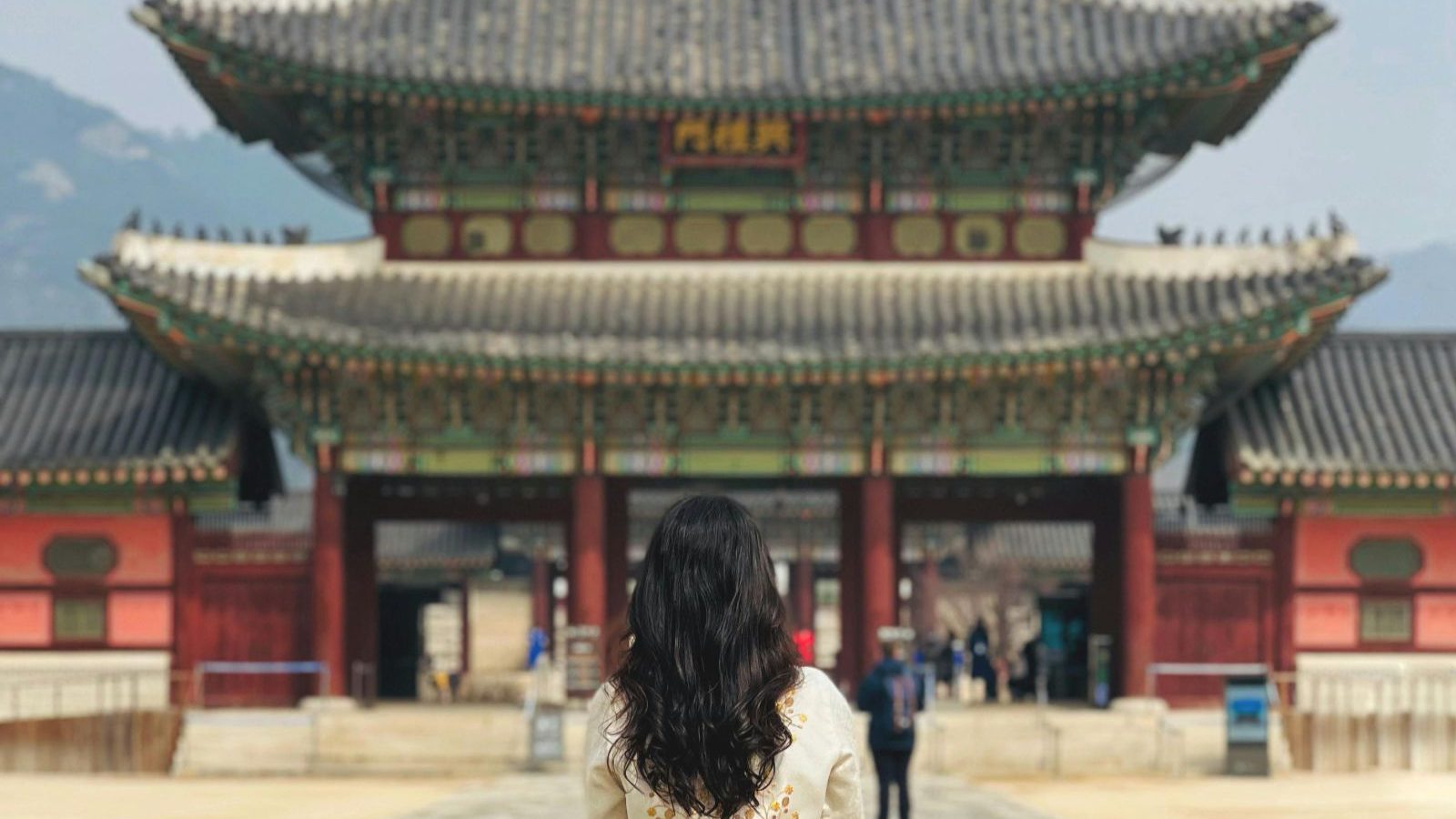 Rondreis Zuid-Korea, Seoul, Gyeongbokgung palace, vrouw met traditionele kleding