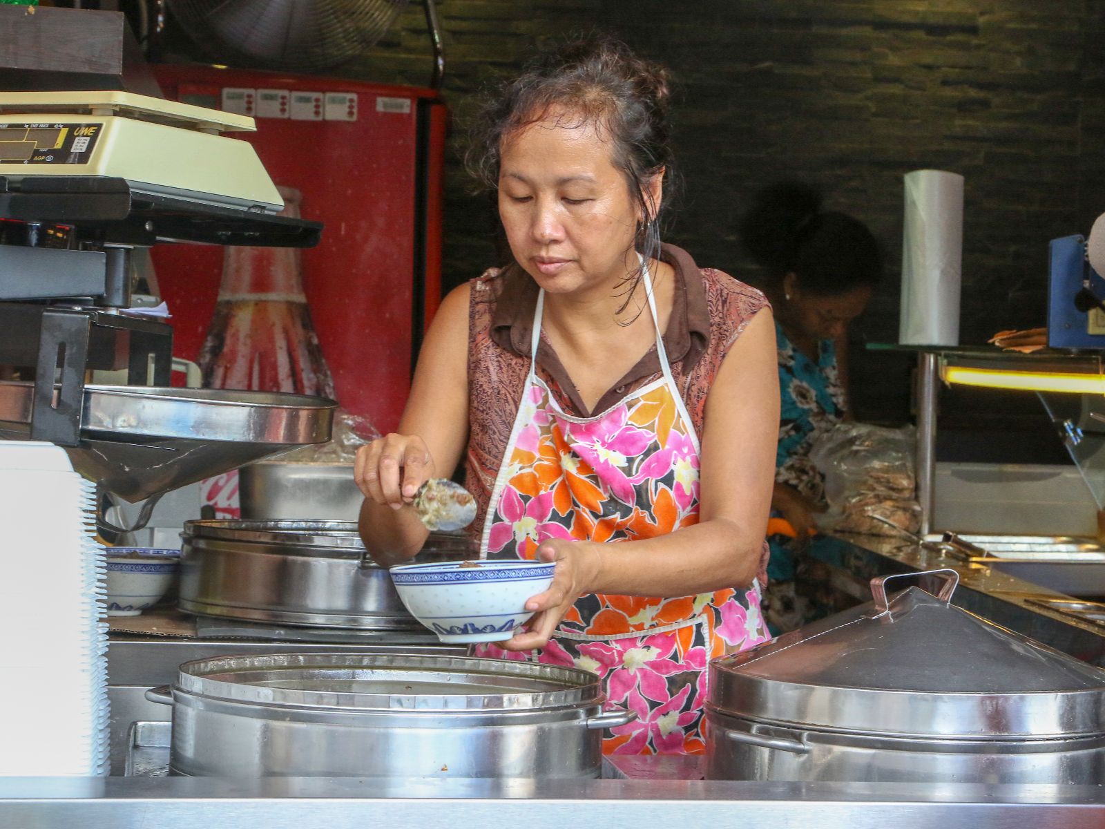 Rondreis Mauritius, Port Louis, Excurie Street Food Tour in Port Louis, vrouw die eten in een bakje doet