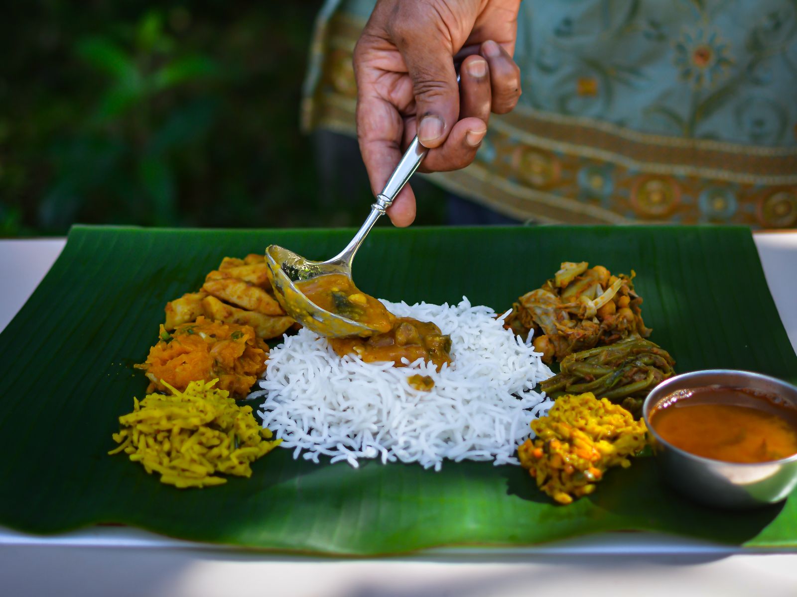 Rondreis Mauritius, vrouw die saus op eten doet, MPTA