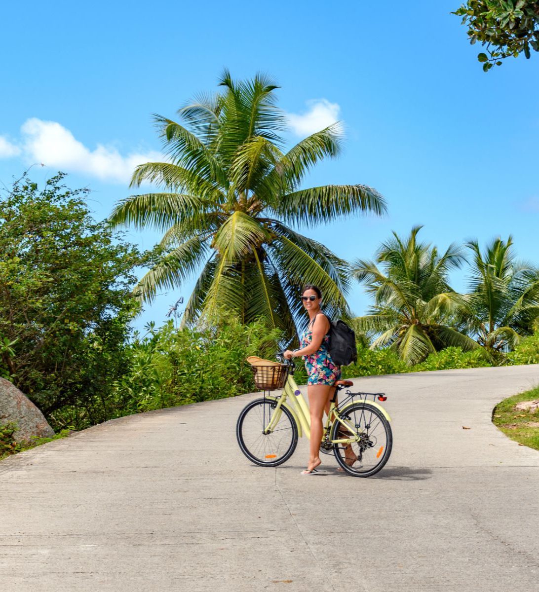 Rondreis Seychellen, excursie van Mahe naar La Digue bikes and beaches, La Digue, vrouw op fiets